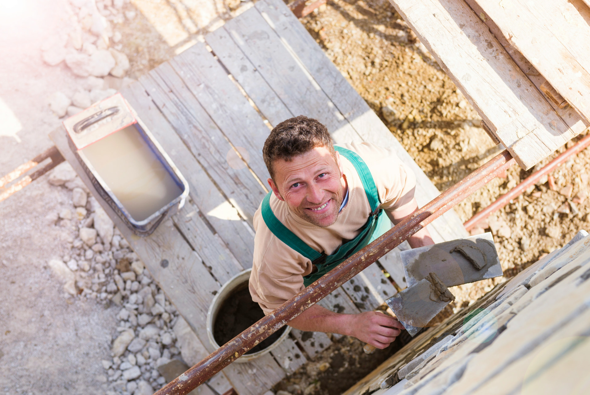 A tradesman looking up from a jobsite with a confident smile — the finished-work moment that earns Google reviews.